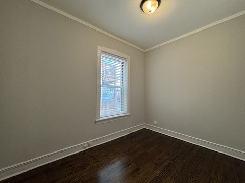A room with a window and wooden flooring.