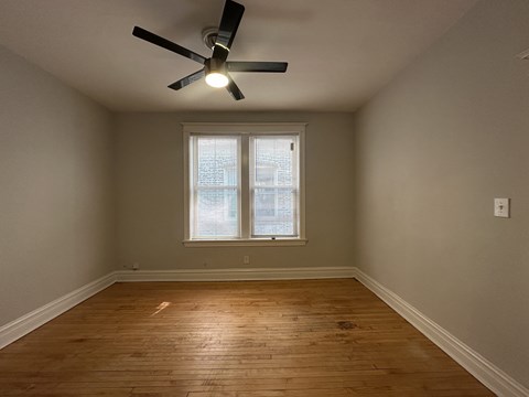 A room with a ceiling fan and a window.