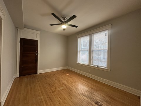 A room with a ceiling fan and a window.