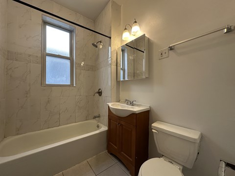 A white toilet sits next to a sink in a bathroom.