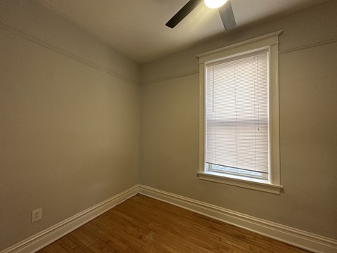 A room with a window and a ceiling fan.