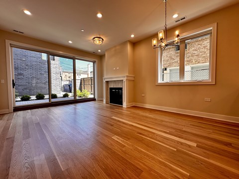 A spacious room with wooden floors and a large window.