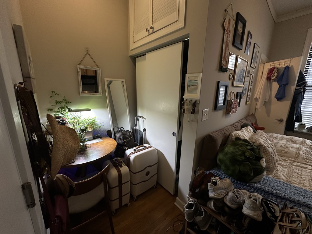 A small room with a bed, a chair, a table, and a closet.
