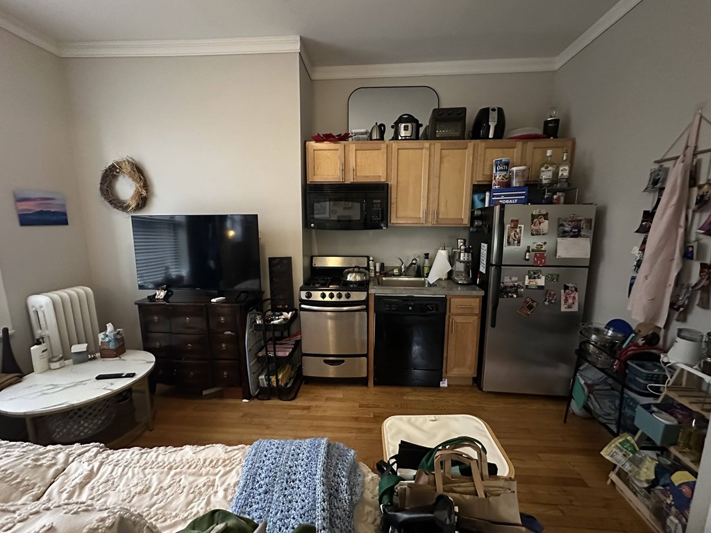A kitchen with a fridge, microwave, and oven.