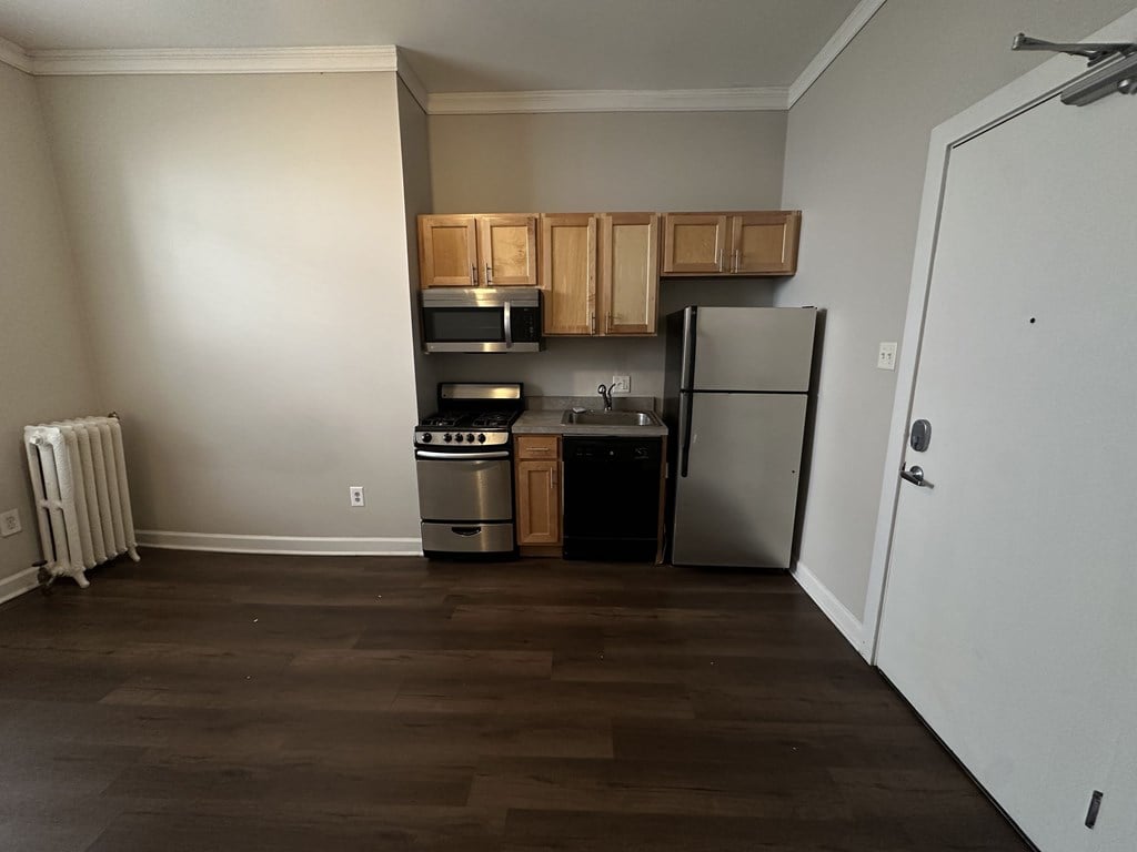 A kitchen with a refrigerator, oven, and microwave.
