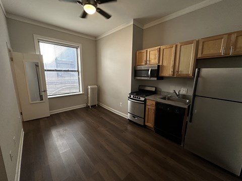 A kitchen with a refrigerator, stove, and microwave.