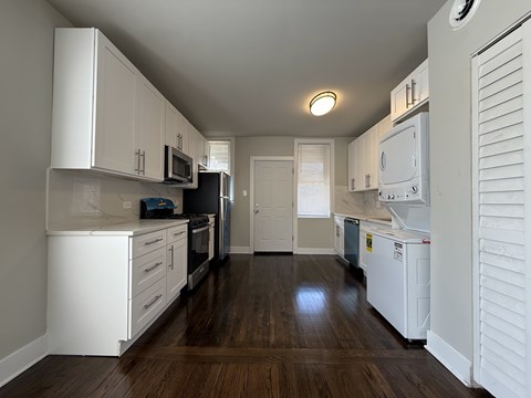 A kitchen with white cabinets and appliances.