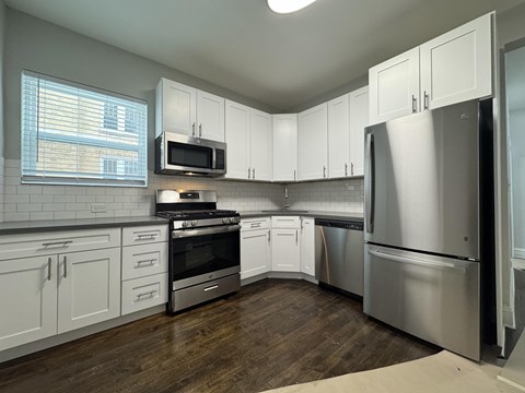 A kitchen with white cabinets and stainless steel appliances.
