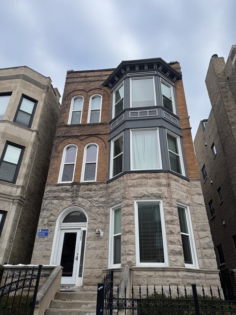 A brown building with a white door and windows.