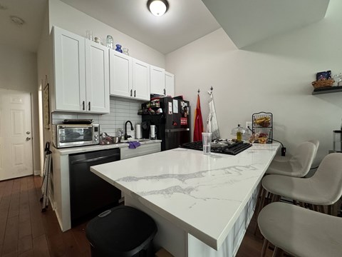 A kitchen with a white countertop and black stove.