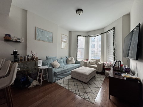 A living room with a grey couch and a white chair.