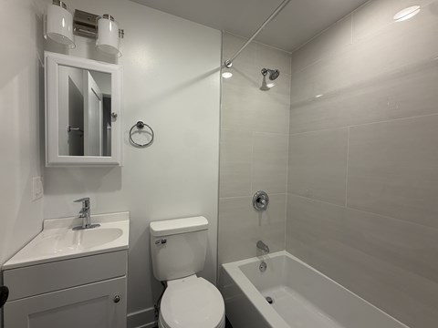 A white bathroom with a toilet, sink, and bathtub.