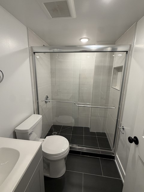 A white toilet sits next to a sink in a small bathroom.
