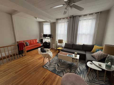 A living room with a red couch and a zebra rug.