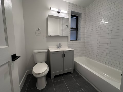A white toilet sits next to a sink in a small bathroom.
