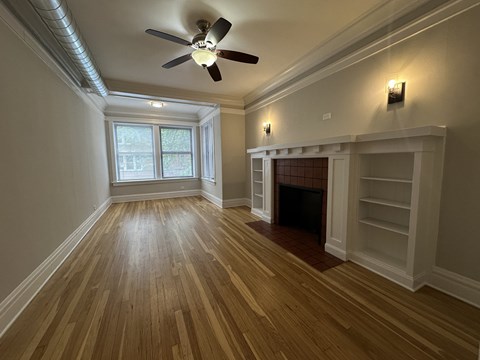 A room with a fireplace and a ceiling fan.
