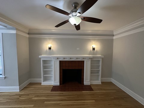 A room with a fireplace and a ceiling fan.