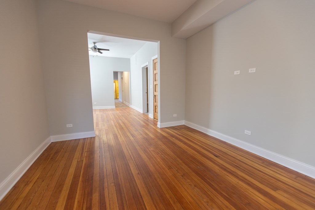 A room with wooden floors and a ceiling fan.