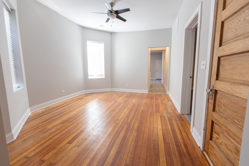 A room with wooden floors and a ceiling fan.