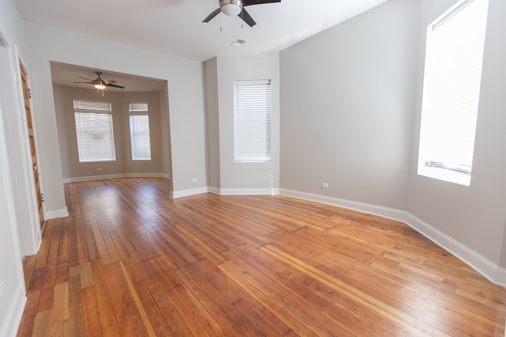 A room with wooden floors and a ceiling fan.