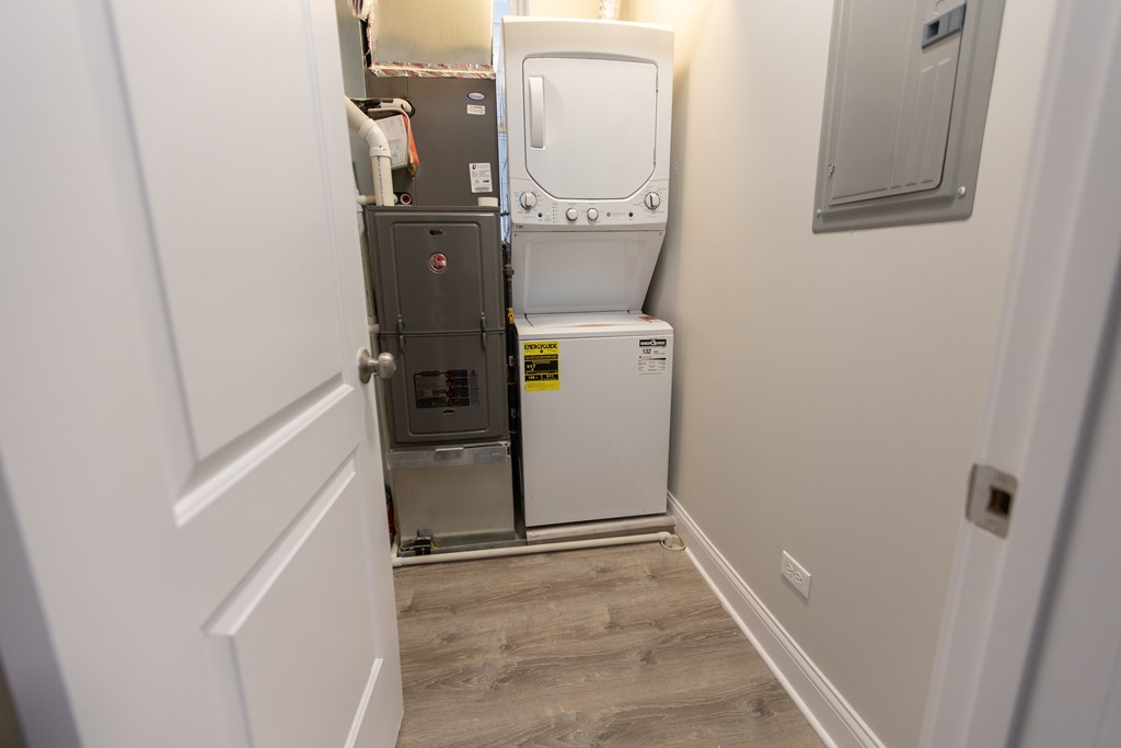 A white toilet is in a small room with a grey cabinet.