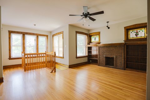 A living room with a fireplace and a fan.