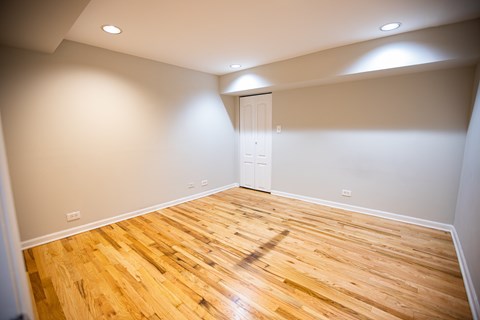 A room with wooden flooring and a white door.