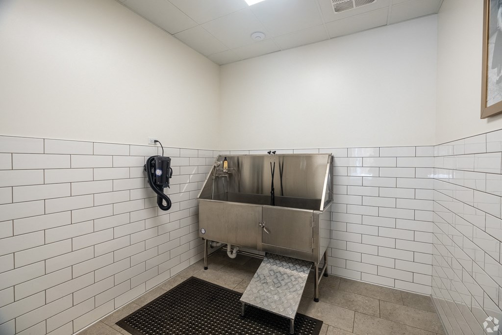 a public bathroom with a stainless steel sink and a urinal