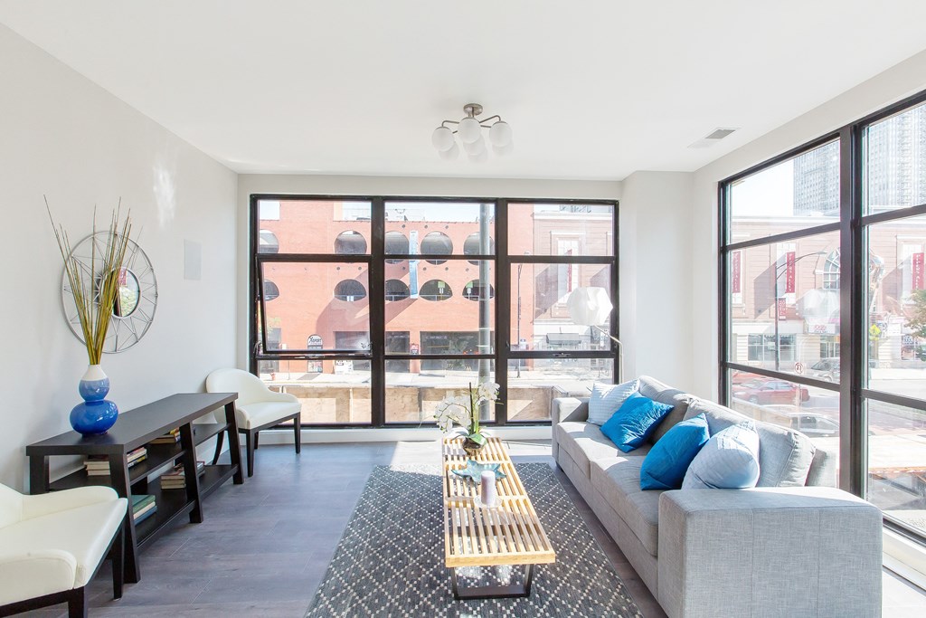 a living room with large windows and a couch and a table