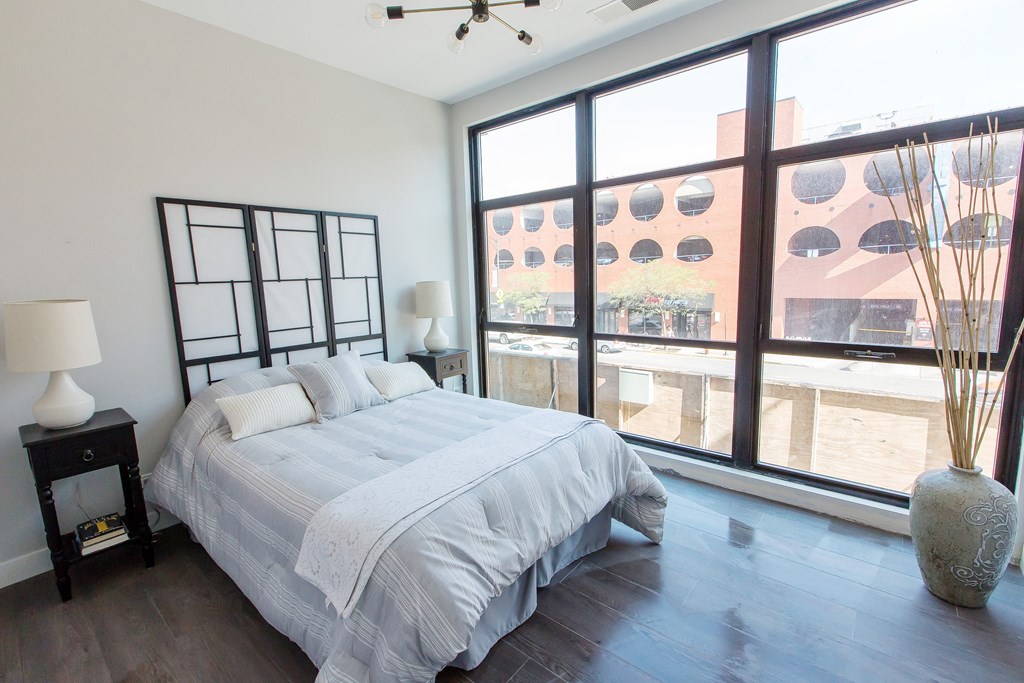a bedroom with a bed and a large window