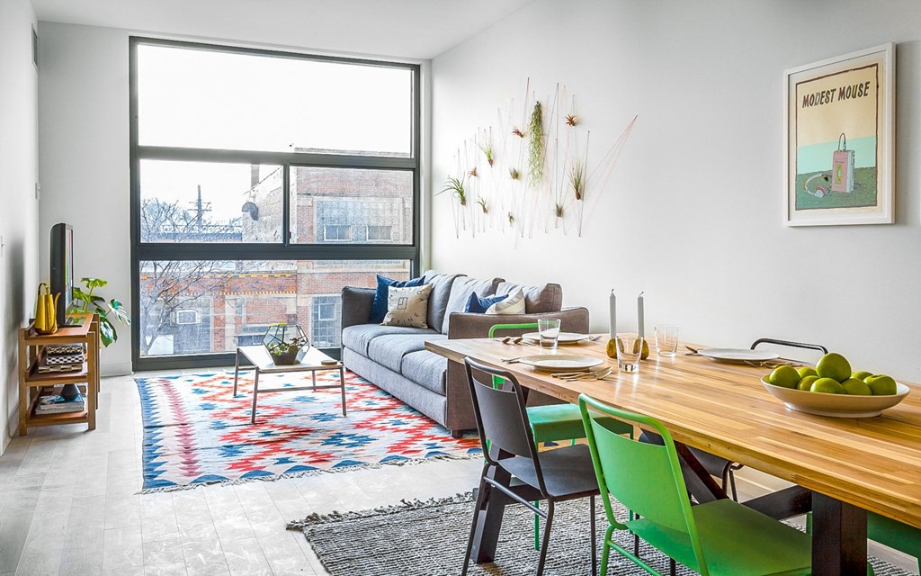 Elegant dining room with a long wooden table and green chairs 