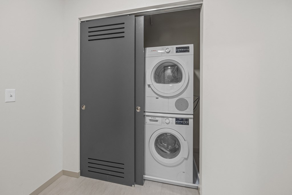 a white washer and dryer in a gray closet