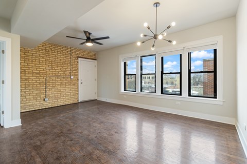 A room with a brick wall and a ceiling fan.
