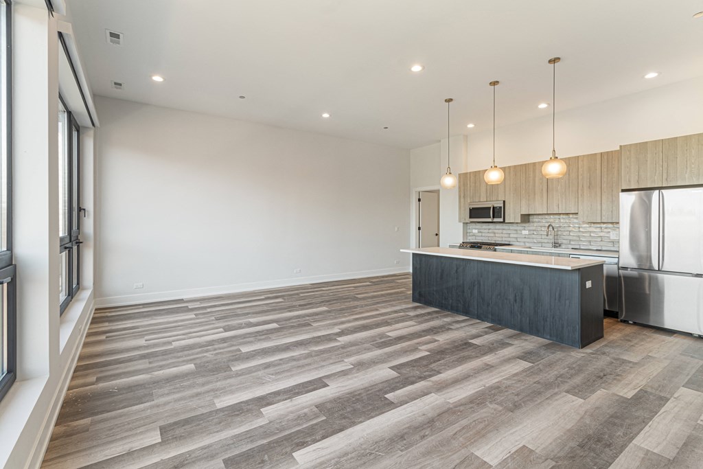 a kitchen and living room with a refrigerator and a sink