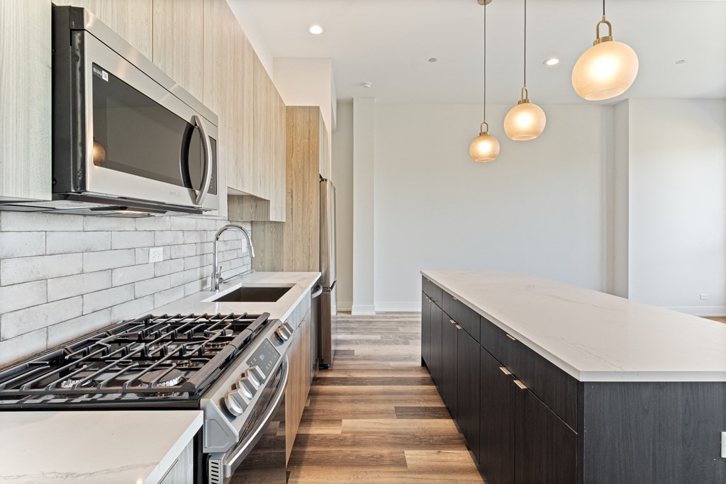a kitchen with white counter tops and a stove and a microwave