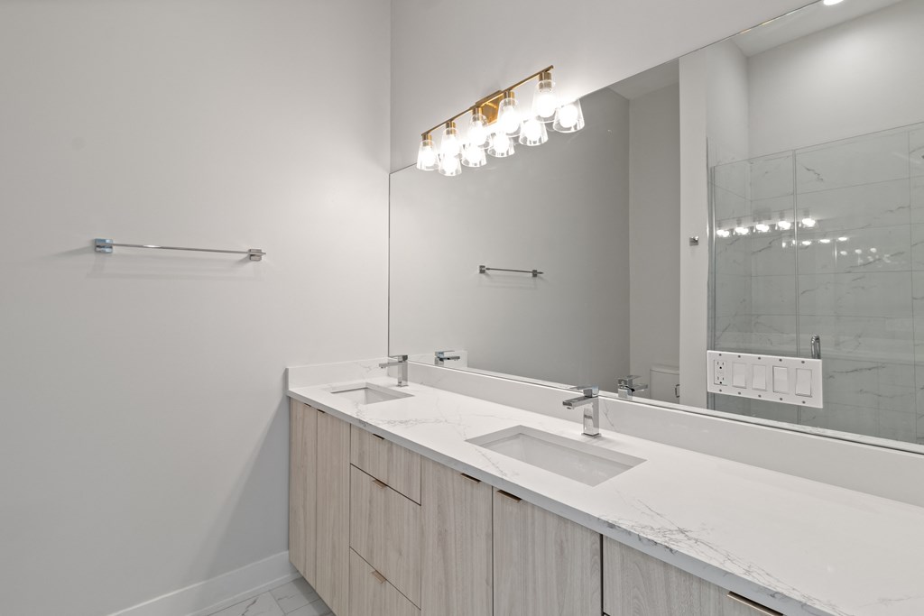 a white bathroom with two sinks and a large mirror