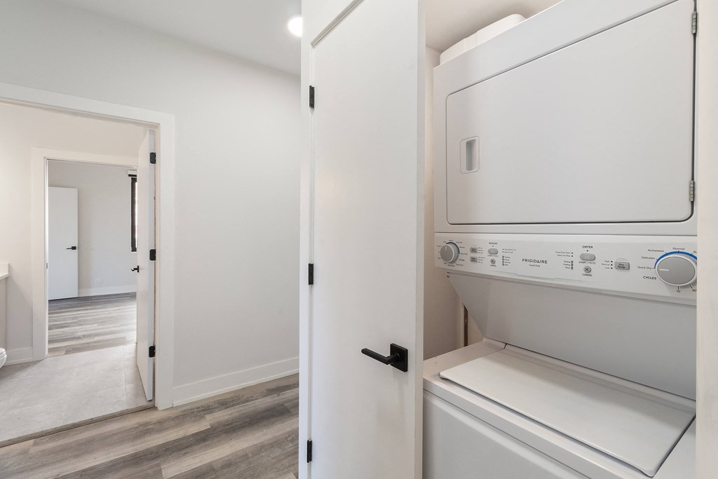 a laundry room with a washer and dryer and a white door