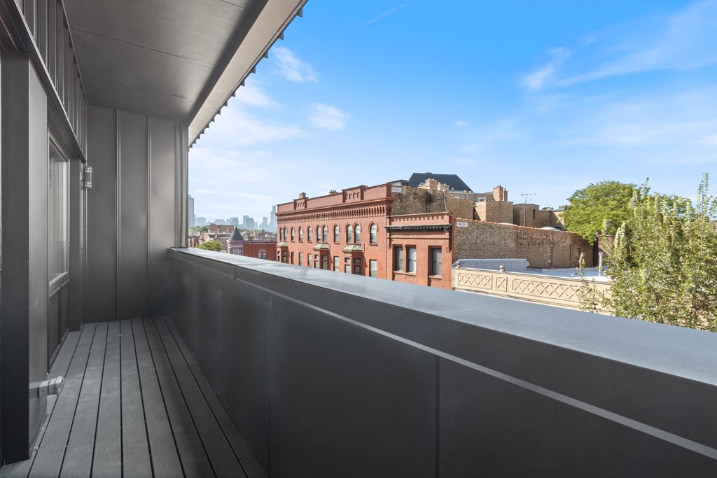 a balcony with a view of a brick building and a blue sky