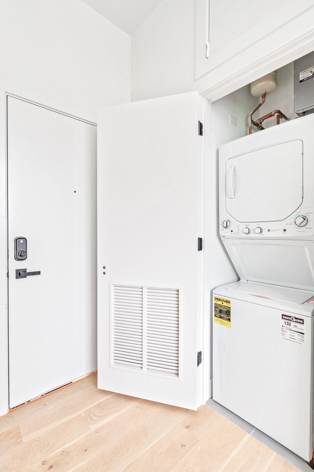 a laundry room with a washer and dryer and a door to the closet