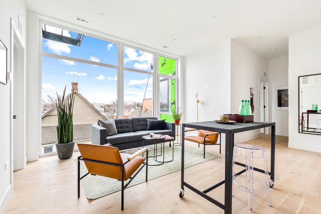 a living room with a large window and a table with chairs