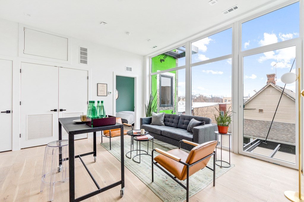 a living room with a large window and a table with chairs