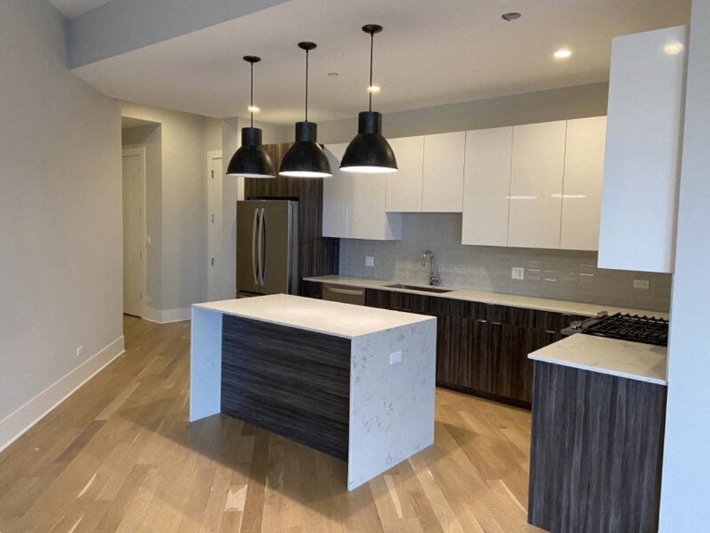 a kitchen with a large island and white cabinets