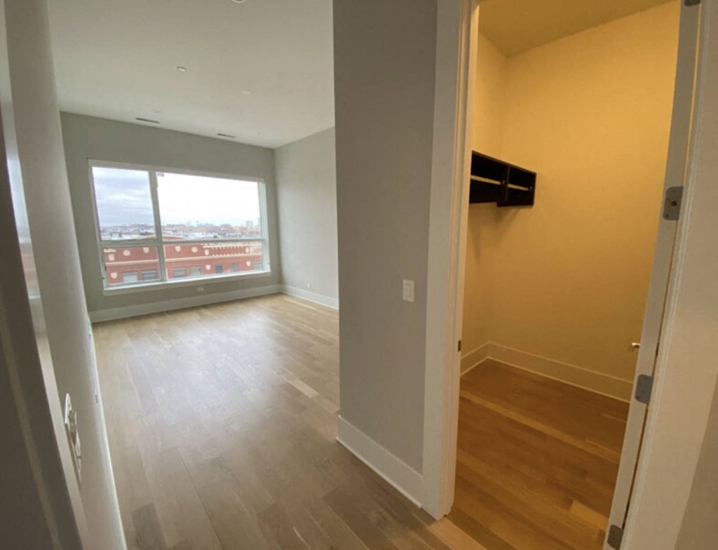 a living room with a large window and wooden floors