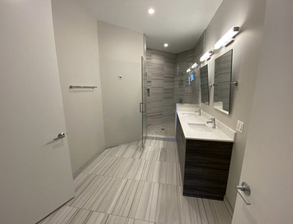 a bathroom with a shower and a sink and a mirror