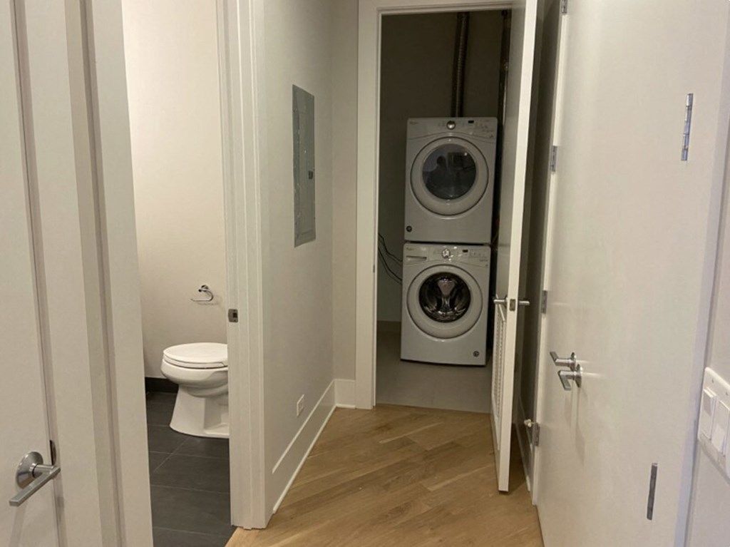 a small bathroom with a washing machine and a toilet