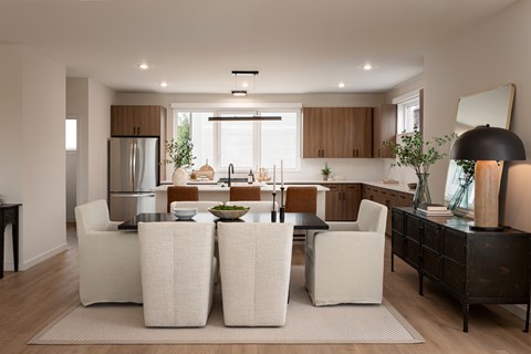 A modern kitchen with white chairs and a wooden cabinet.