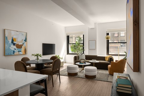 A modern living room with a white dining table and brown chairs.