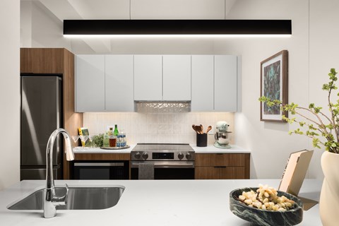 A modern kitchen with a stainless steel sink and a refrigerator.