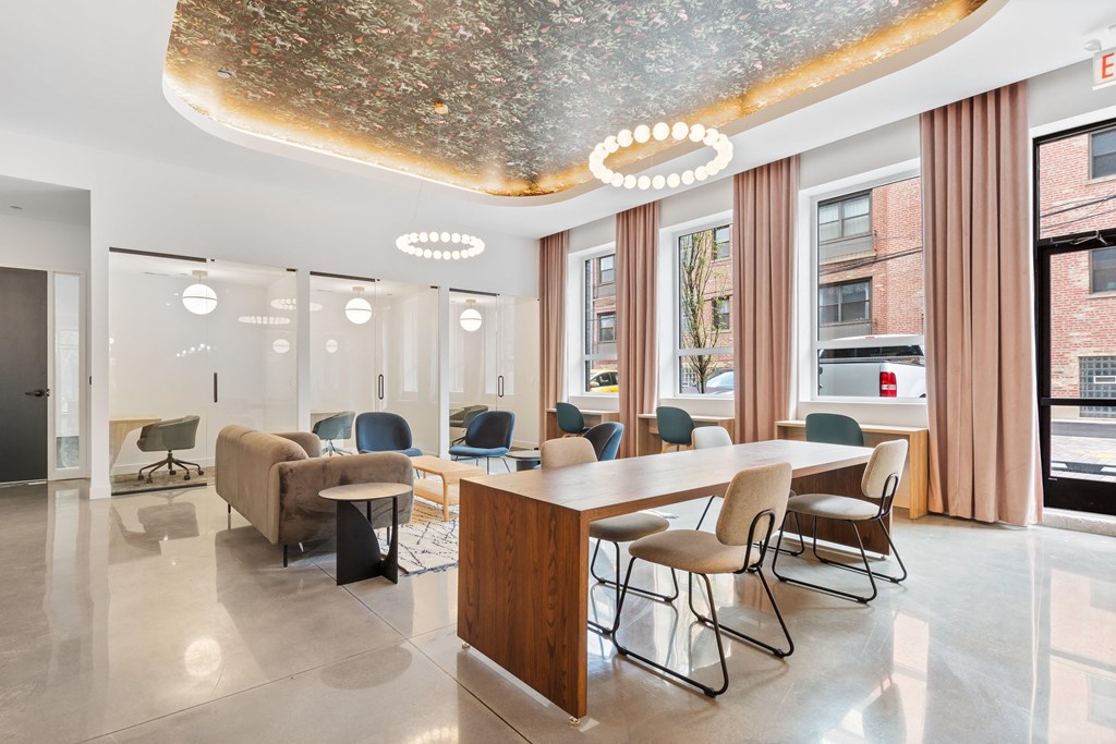 a room with a long table with chairs and a large window