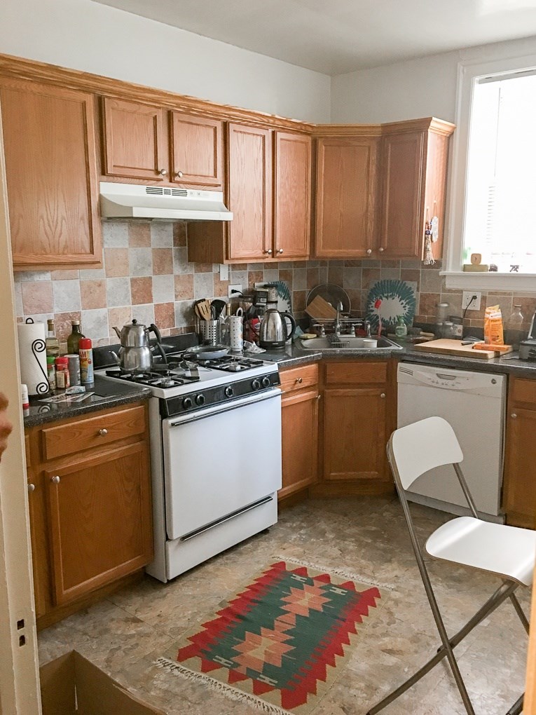 A kitchen with wooden cabinets and a white stove top oven.